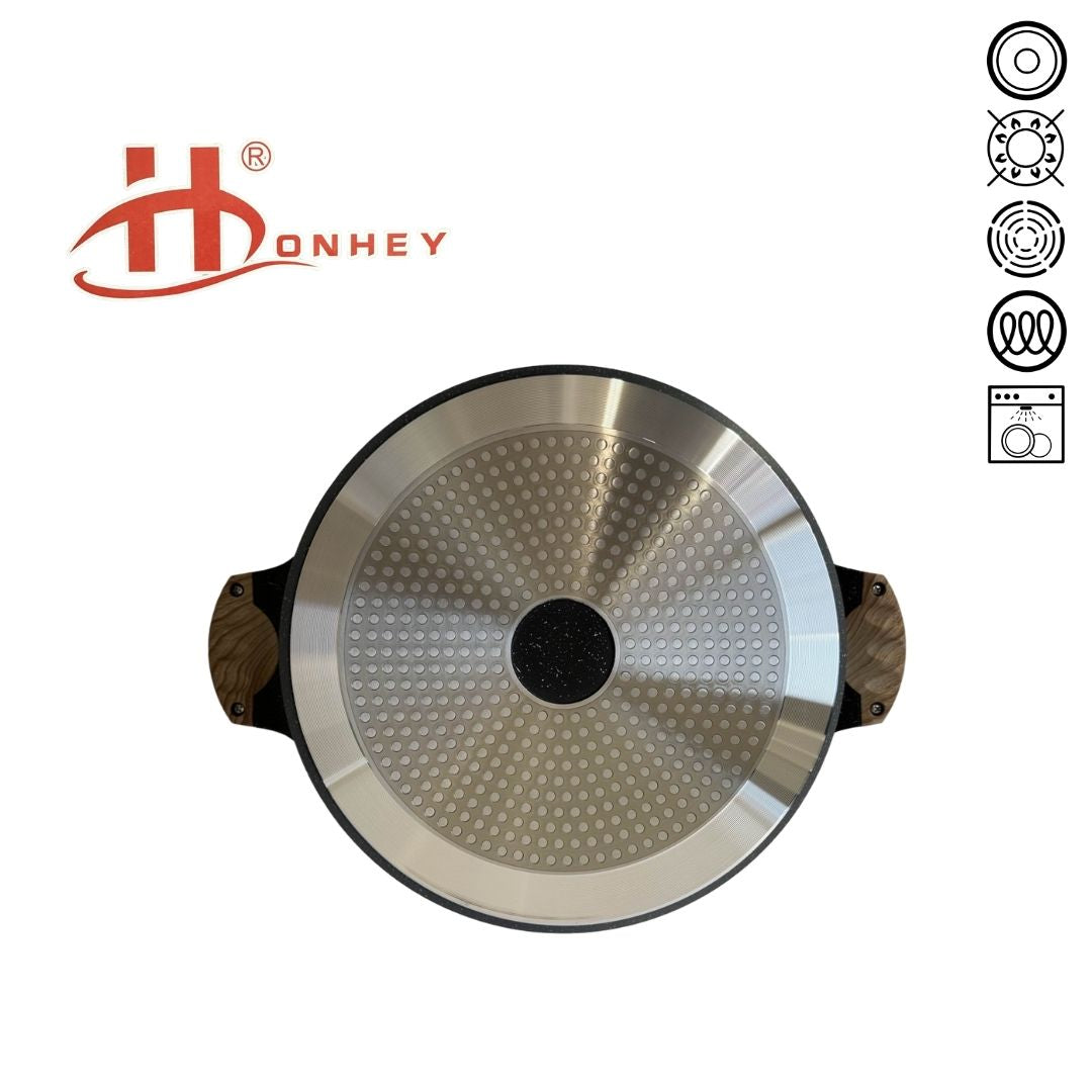Bottom view of a non-stick shallow pot with a smooth, brushed metal surface and a concentric circular pattern laying against a white background.
